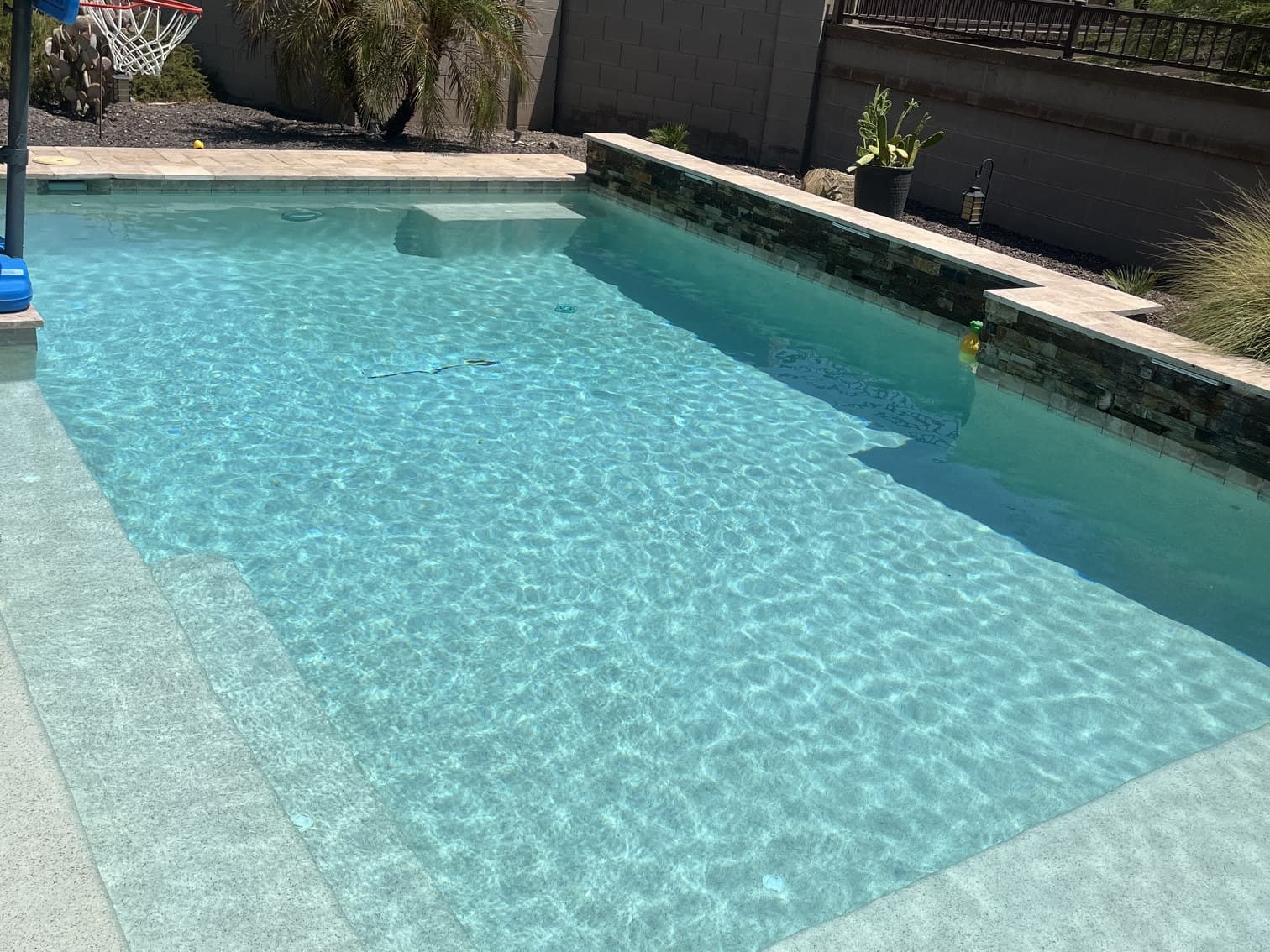 Clean backyard pool with raised spa serviced by Flow State Pool Services in Peoria, AZ